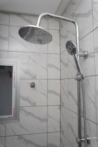 um chuveiro com chuveiro em um banheiro em Martha House Bonapriso Douala em Douala