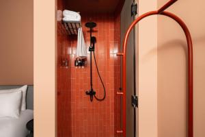 uma casa de banho com chuveiro e azulejos vermelhos em grey l studio apartments Downtown Cairo Bidair House em Cairo mais 43 fotografias