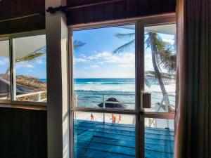 ein Fenster mit Blick auf den Strand und das Meer in der Unterkunft Beach Cabana By why not hikkaduwa in Hikkaduwa