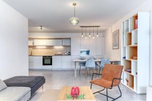 a living room and kitchen with a couch and a table at Vinatier - Lyon 2 - LB - Large family apartment with parking in Lyon in Bron +9 photos