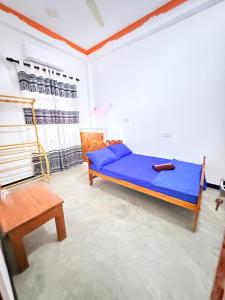 a bedroom with a blue bed in a room at J Rest in in Trincomalee