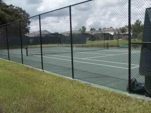 a tennis court with two people playing tennis at Lake Berkley 5 bedrm 3 bath villa near Disneyland in Kissimmee