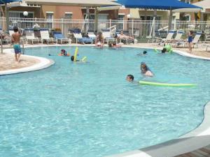 a group of people in a swimming pool with surfboards at Lake Berkley 5 bedrm 3 bath villa near Disneyland in Kissimmee
