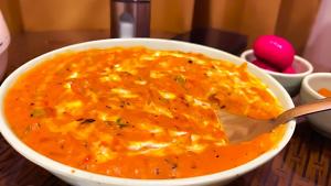 リシケーシュにあるCheck Inn Homes, Rishikesh Tapovanのスプーンが入ったチーズスープのボウル