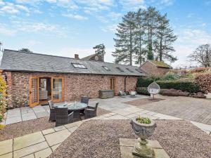 a stone house with a patio with a table and chairs at 2 Bed in Leominster 50518 in Pencombe