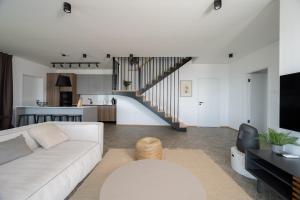 a living room with a white couch and a staircase at Wild Adriatic Way in Labin