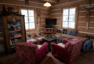 a living room with a couch and chairs and a tv at Roubená chalupa Máca in Vrchlabí