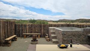 a patio with a hot tub and a wooden fence at Izinga Game Karoo Guest Farm in Philipstown