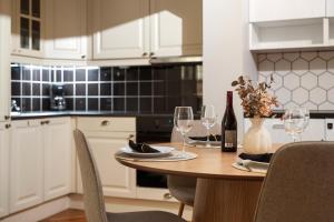 een keuken met een houten tafel met wijnglazen bij ARCTIC HOMES - Harmony Retreat in Tromsø