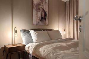 een slaapkamer met een bed en een schilderij aan de muur bij ARCTIC HOMES - Harmony Retreat in Tromsø +5 foto's