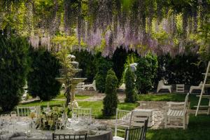 a table in a garden with purple wisterias at Open Concept Boutique Hotel - free breakfast & parking in Belgrade