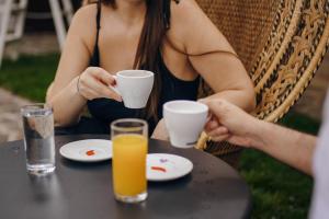 a woman sitting at a table with a cup of orange juice at Open Concept Boutique Hotel - free breakfast & parking in Belgrade +38 photos