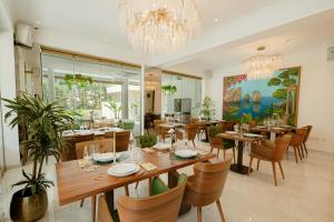 una sala da pranzo con tavoli e sedie e un lampadario di Averde Residence a Larnaka