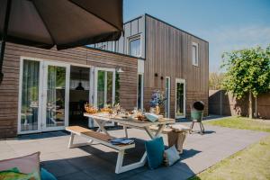 Un patio con una mesa y sillas frente a una casa. en Zindering Renesse, en Renesse