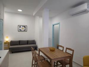 a dining room with a table and chairs and a couch at Casa Quarzo, bright and a stone's throw from the beach in Gaeta