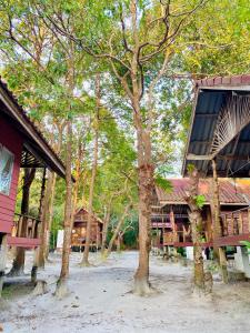 a group of trees in front of a building at Lucky Resort in Ko Phayam