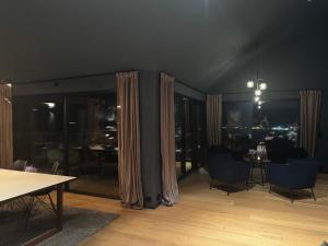 Gammelgårdvegen 31 في ترومسو: غرفة معيشة مع طاولة وكراسي وستائر