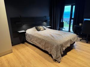 Gammelgårdvegen 31 في ترومسو: غرفة نوم بها سرير ونافذة كبيرة