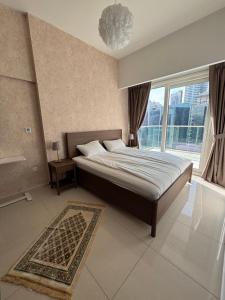 SabkhahMama's Crib Dubai的一间卧室，里面有一张床和一扇大窗户。 更多33张照片