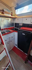 Una pequeña cocina con fregadero y estufa. en Grand voilier avec tout confort, en Cherbourg-en-Cotentin