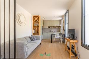 un soggiorno con un divano e un tavolo di Raspail B - IDF - LB - Charming house at gates of Paris 3 people a Bois-Colombes