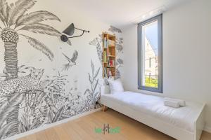 una camera da letto con un murale di palme sul muro di Raspail B - IDF - LB - Charming house at gates of Paris 3 people a Bois-Colombes