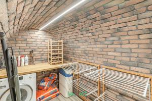 una lavanderia con pareti in mattoni, lavatrice e asciugatrice di Raspail B - IDF - LB - Charming house at gates of Paris 3 people a Bois-Colombes