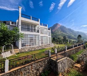 una casa con una montaña al fondo en Villa Rosaria, en Beragala