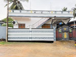 a white building with a gate and a staircase at J Rest in in Trincomalee