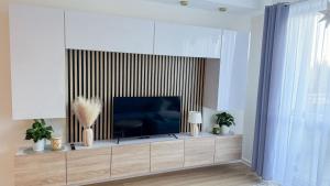 a living room with a flat screen tv on a entertainment center at Apartament Ptasia Góra in Kłodzko