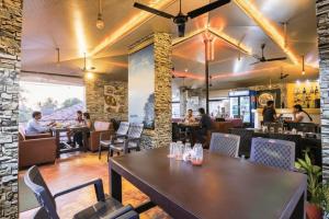 un restaurante con mesa y gente sentada en mesas en Via Victoria With Pool - Nr Baga Beach, en Baga