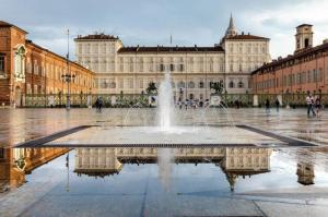 a fountain in front of a large building at Q suites urban relais in Turin
