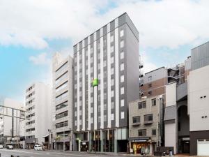 um prédio alto e branco em uma rua da cidade em ibis Styles Kyoto Shijo em Quioto mais 109 fotografias