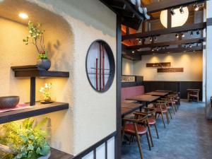 Un restaurante con mesas y sillas y un espejo en la pared. en ibis Styles Kyoto Shijo, en Kioto