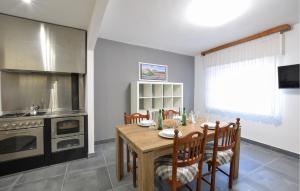 a kitchen with a wooden table with chairs and an oven at Nice Home In Longarone With Wifi in Faè