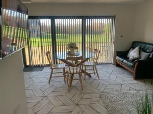 a living room with a table and chairs and a couch at Field View in Wormegay