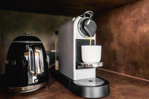 una macchinetta del caffè seduta su un bancone con una tazza di Ostravinka - Boutique Cabin a Ostrava