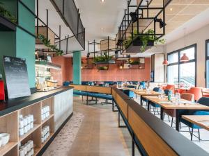 a dining room with tables and chairs and a restaurant at ibis Lyon Sud Oullins in Oullins