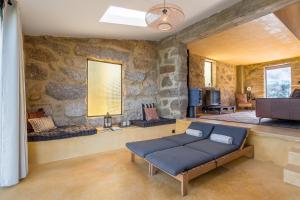 a living room with a couch and a stone wall at Lemon Villa with Private Indoor Heated Pool - Oporto Lemon Farm, near Porto in Valpedre