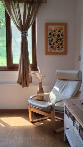 a room with a chair in front of a window at Agroturism Sesuri 151 in Şesuri