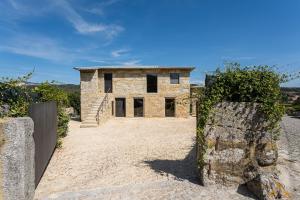 a stone house with a gate in front of it at Lemon Villa with Private Indoor Heated Pool - Oporto Lemon Farm, near Porto in Valpedre