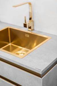 złoty zlew w blacie kuchennym w obiekcie Hanza Tower SKY GOLD 24 Sauna & Jacuzzi & Pool & SPA w Szczecinie +12 zdjęć