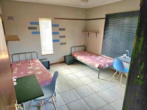 a room with two beds and a sink in it at Waterworks Overnights in Kimberley