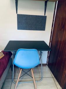 a blue chair sitting at a desk next to a bed at Waterworks Overnights in Kimberley