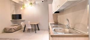 圣雷莫Petronilla House 008055-LT-1202的厨房配有水槽、桌子和电视。