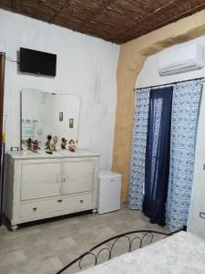 1 dormitorio con espejo y vestidor en una habitación en Casa Pili, en San Vito