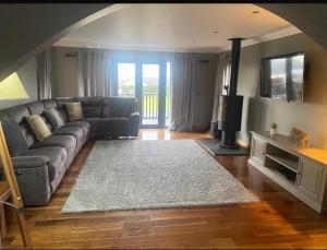 a living room with a couch and a rug at Modern timber clad house in Stornoway