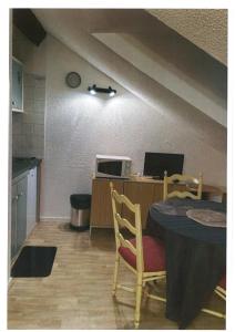 una cucina con tavolo e una scrivania con forno a microonde di Le grand duc17 a Cauterets