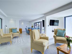 a living room with chairs and a table at Mossel-Bay Waterfront Accommodation in Linkside