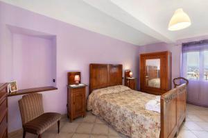 a bedroom with a bed and a chair and a window at Magnifico Roero Relax Tre Camere in Canale